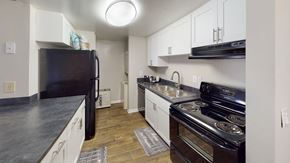 Tampa apartment for rent - a kitchen with white cabinets and black appliances at Laurel Oaks Apartments, Tampa