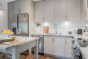 Fort Myers apartment for rent - a kitchen with white cabinets and marble countertops at The Lotus at Village Walk, Fort Myers, Florida