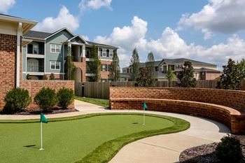 Exterior view of apartment building with putting green in front