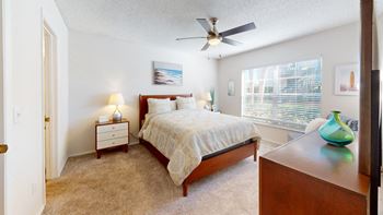 A bedroom with a bed and a ceiling fan
