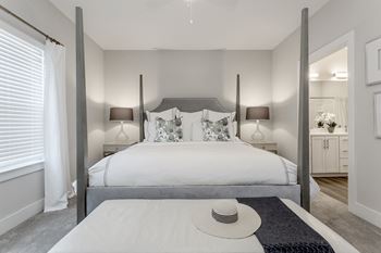 A bedroom with a bed and a hat on a table