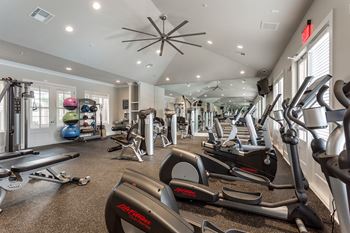 View of fitness center with cardio machines and weights