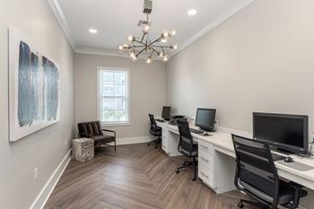 Business center office with two desks and two computers and a chandelier