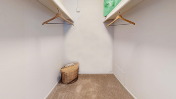 A closet with two shelves and a basket in the corner