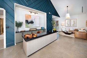 A kitchen with a counter and a living room