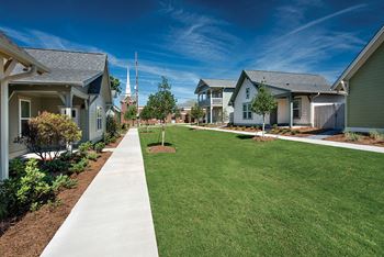 A green lawn in front of a row of houses