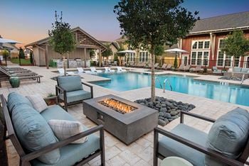 A swimming pool with patio furniture and a fire pit