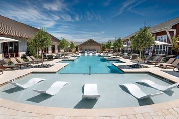 A large swimming pool with lounge chairs and umbrellas