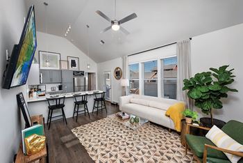 A living room with a white couch, a green chair, and a patterned rug.
