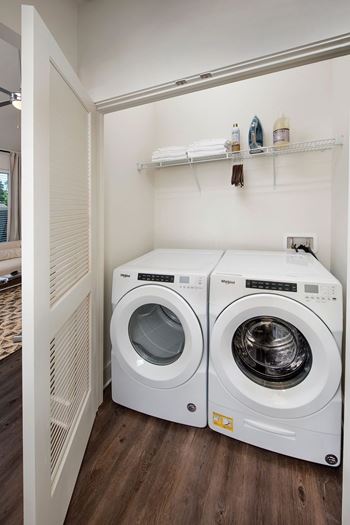 A small laundry room with two front loading washing machines.