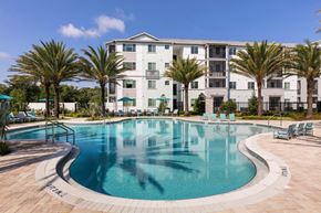 South Daytona apartment for rent - a large swimming pool with an apartment building in the background at Enclave at 3230 Apartments, South Daytona, Florida