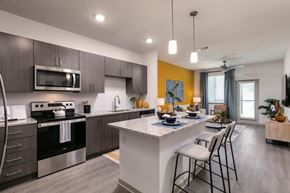South Daytona apartment for rent - A modern kitchen with a breakfast bar and a dining area at Enclave at 3230 Apartments, Florida, 32119