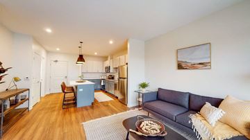 St. Paul apartment for rent - A living room with a grey couch and a coffee table with food on it.