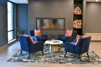 A living room with a fireplace and blue chairs.