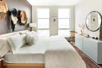 Bright bedroom with neutral bedding and decorative wall accents