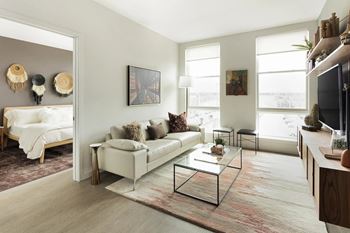 Living room with glass coffee table and large windows
