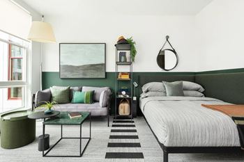 Studio apartment with green accent wall and lounge seating