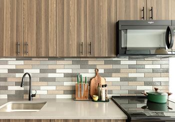 Kitchen with wood grain cabinets and subway tile backsplash