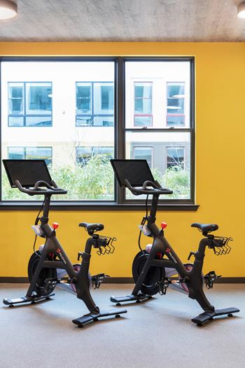 Fitness center with stationary bikes and concrete ceiling