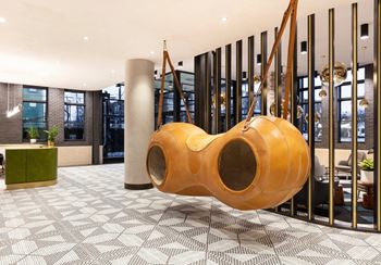 Lobby with hanging sculptural seating and vertical partition