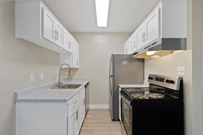 Tucson apartment for rent - Kitchen with white cabinets and a black stove and refrigerator at Elevation Apartments, AZ, 85718
