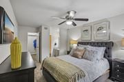 Houston apartment for rent - A bedroom with a large bed and a ceiling fan.