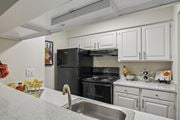 Houston apartment for rent - A kitchen with white cabinets and a black stove top oven.