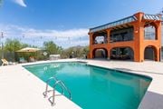 Tucson apartment for rent - A large orange building with a pool in front at Elevation Apartments, Tucson, 85718