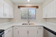Tucson apartment for rent - A kitchen with white cabinets and a window with blinds.at San Xavier Casitas, Tucson, AZ 85716