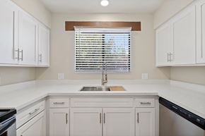 Tucson apartment for rent - A kitchen with white cabinets and a window with blinds.at San Xavier Casitas, Tucson, AZ 85716