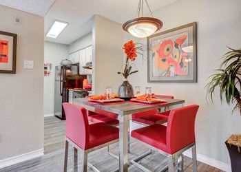 Dining area with a table and chairs and a kitchen in the background