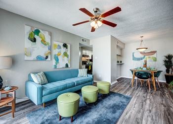 A living room with a blue couch and green chairs