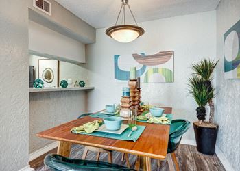 A dining area with a wooden table and green chairs