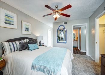 A bedroom with a bed and a ceiling fan