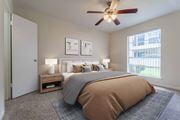 Houston apartment for rent - A bedroom with a large bed and a ceiling fan.