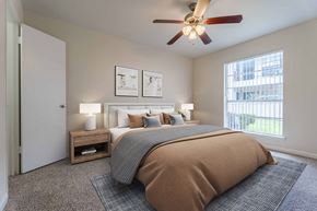 Houston apartment for rent - A bedroom with a large bed and a ceiling fan.
