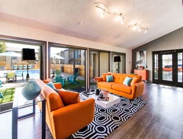 College Station apartment for rent - a living room with orange couches and a rug and sliding glass doors