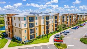 Lady Lake apartment for rent - A row of apartment buildings with cars parked in the driveway.