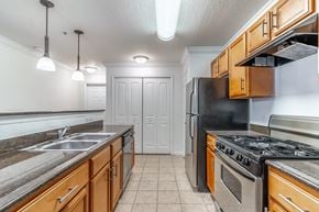 Deland apartment for rent - a kitchen with stainless steel appliances and wooden cabinets