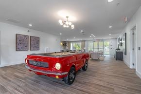 Palm Coast apartment for rent - A red vintage car is parked in a spacious room with wood flooring.