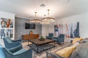 Lady Lake apartment for rent - A living room with a grey couch, a wooden coffee table, and a chandelier.