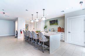 Daytona Beach apartment for rent - a large white kitchen with a long island and chairs