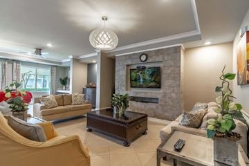Winter Park apartment for rent - A living room with a stone fireplace and a television above it.