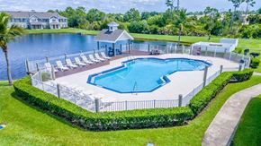 Port St. Lucie apartment for rent - A pool surrounded by a white fence and a small gazebo.