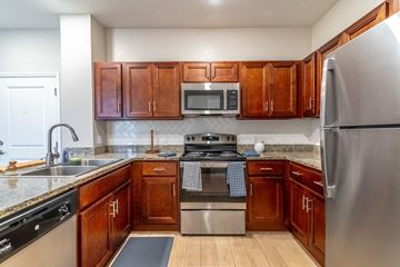 Lady Lake apartment for rent - A kitchen with wooden cabinets and stainless steel appliances.