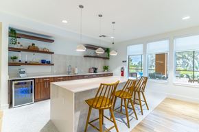 Mount Dora apartment for rent - A kitchen with a white island and wooden chairs.