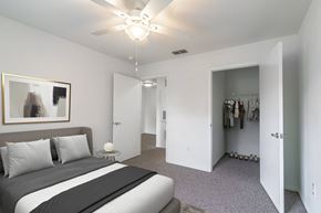 Kissimmee apartment for rent - A bedroom with a large bed and a ceiling fan.