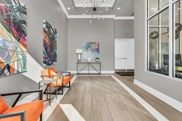 Orlando apartment for rent - a living room with orange chairs and a table and a chandelier