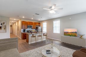 Lady Lake apartment for rent - a living room with a kitchen and a ceiling fan