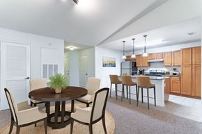 Kissimmee townhouse for rent - a dining area with a table and chairs and a kitchen in the background